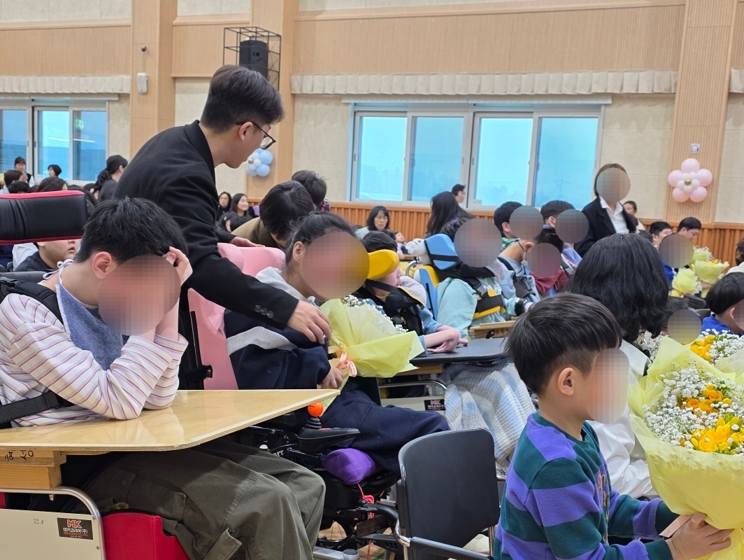 입학식에서 꽃다발을 받고 있는 이용자
