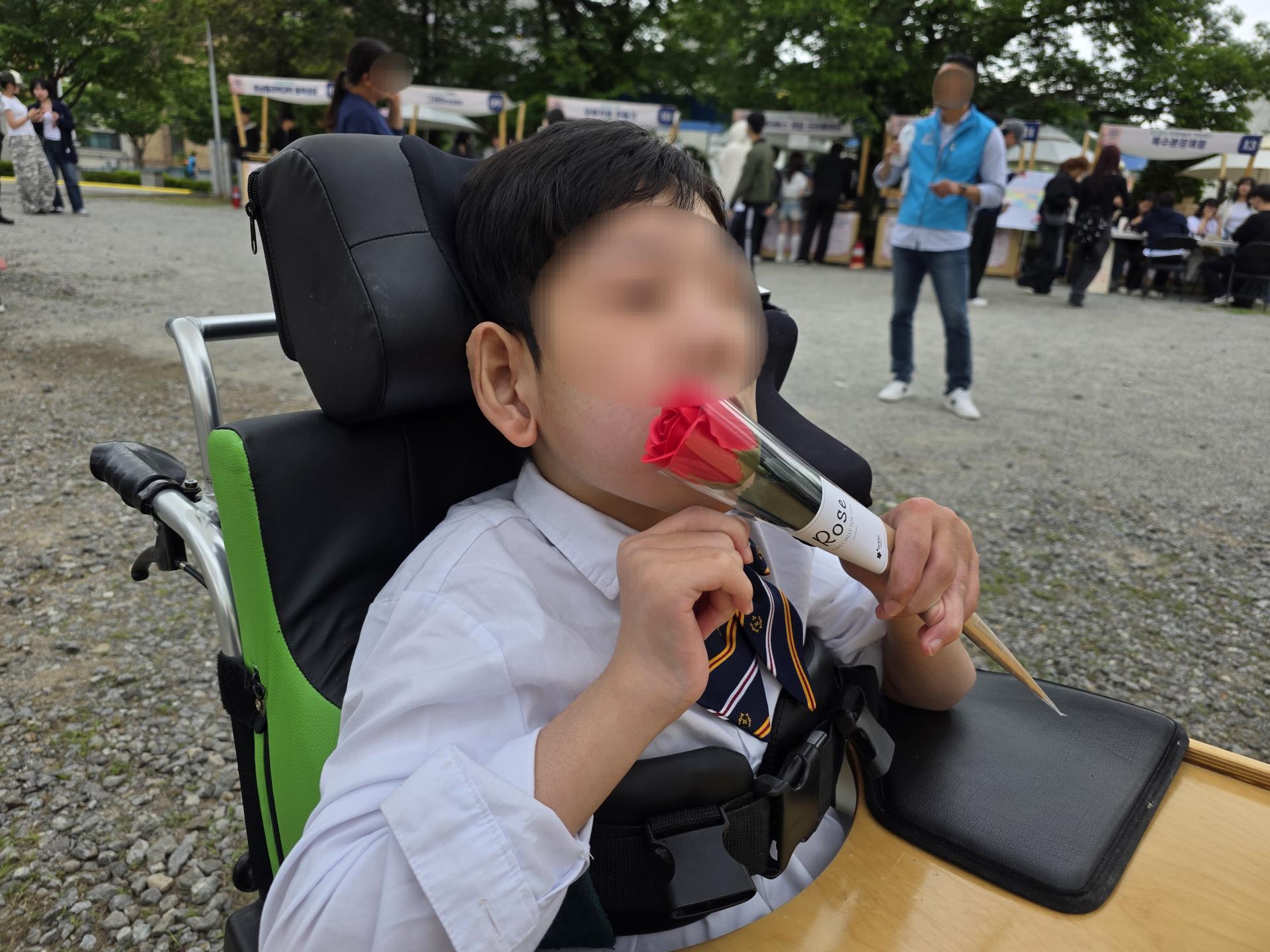 기념식에서 받은 장미꽃을 들고있는 이용자