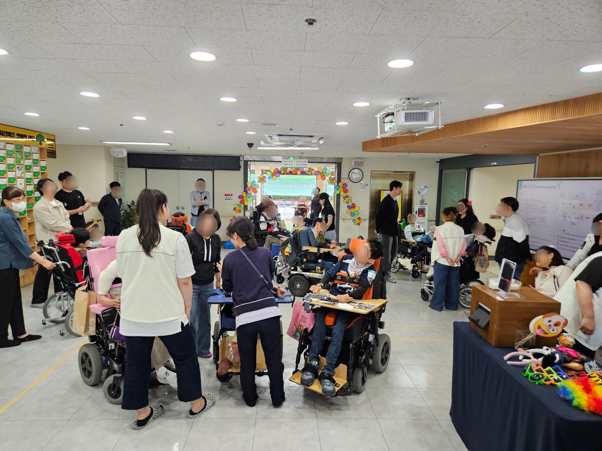 로비에 모여 이야기를 나누는 초청된 이용자들, 한사랑마을 이용자 및 직원들