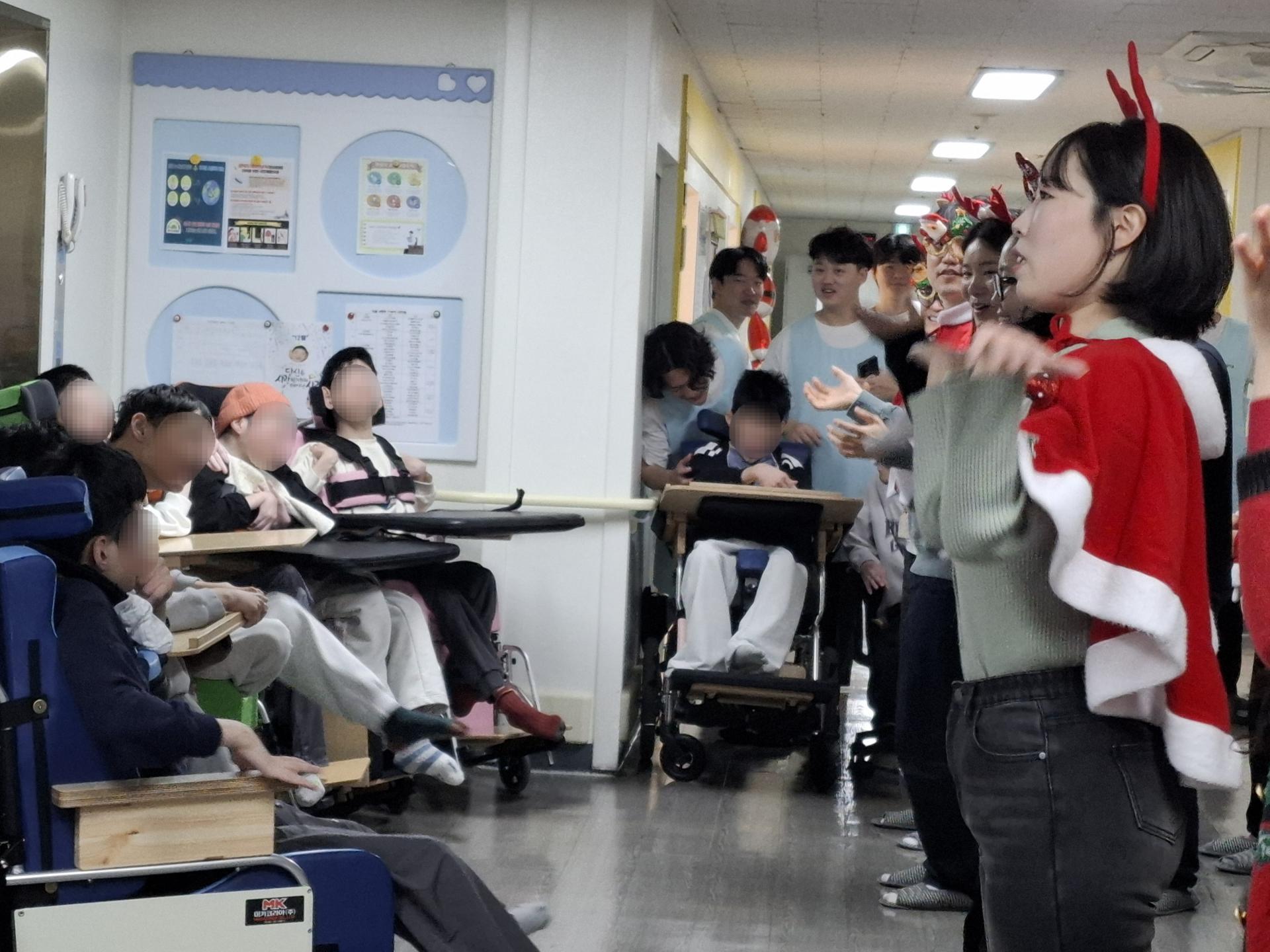 캐롤 율동 공연을 하는 봉사자들과 바라보는 이용자들