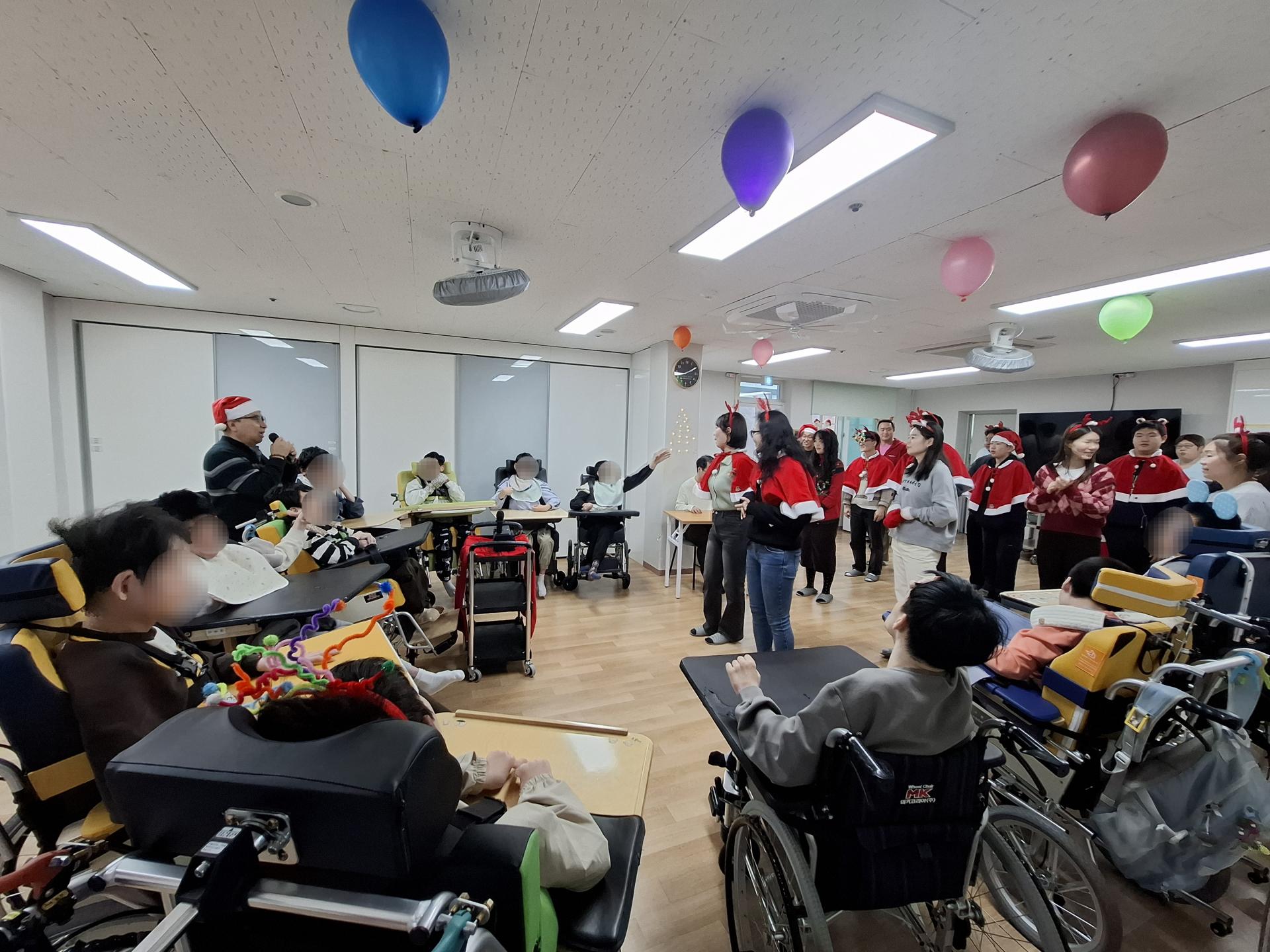 캐롤 율동 공연을 하는 봉사자들과 바라보는 이용자들