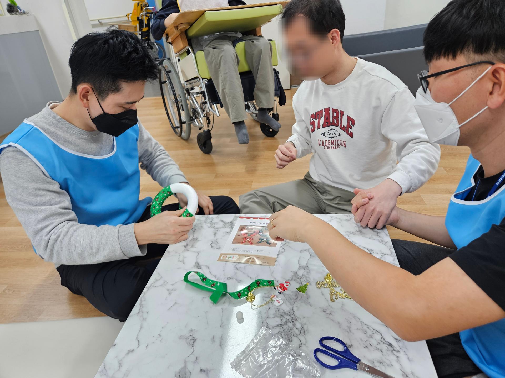 이용자와 함께 트리를 만드는 봉사자