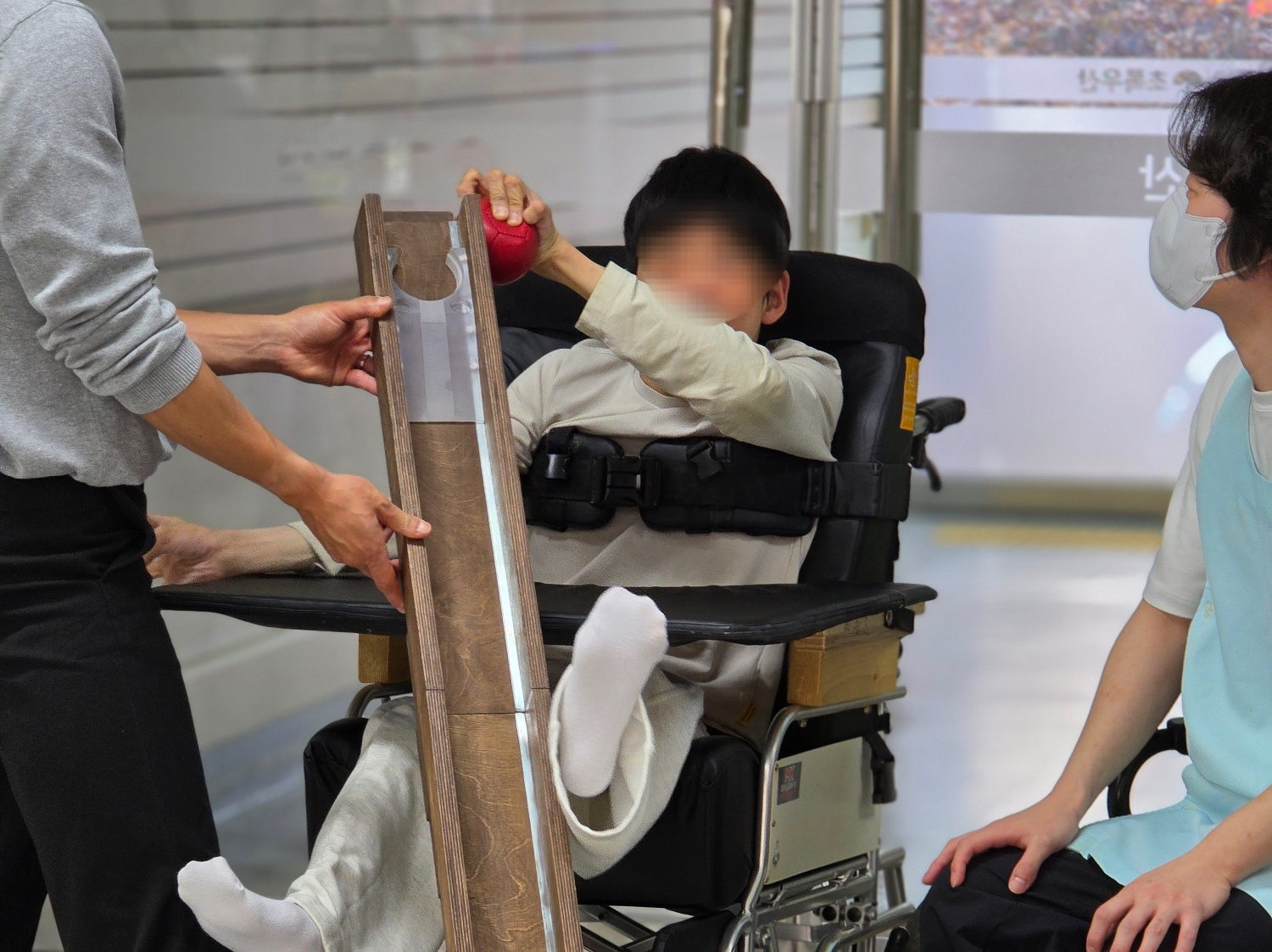 공 굴리기를 준비하는 이용자와 옆에서 지켜보는 이용자,직원들