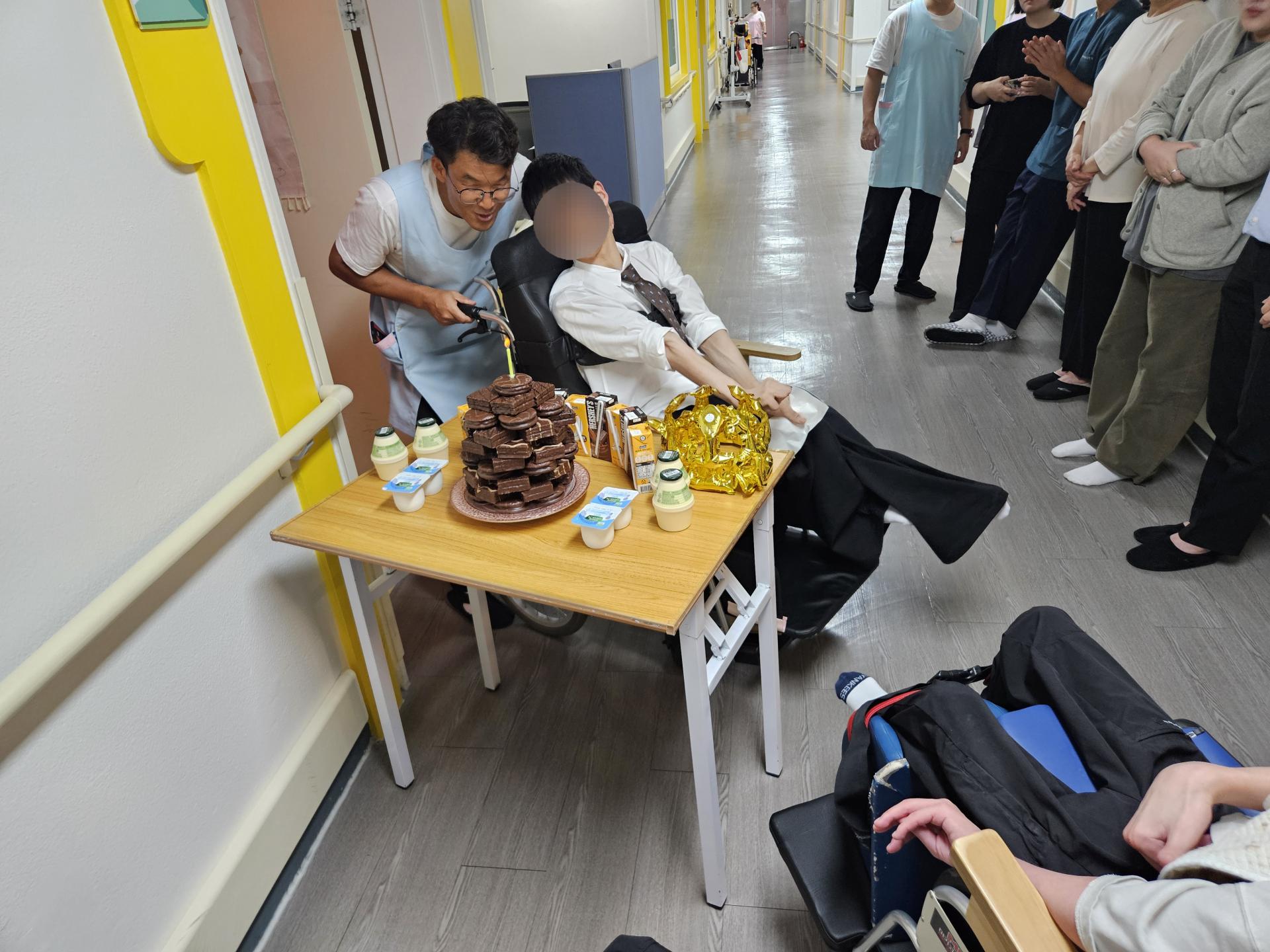 초코파이로 만든 케이크 촛불을 함께 끄고 있는 이용자와 직원