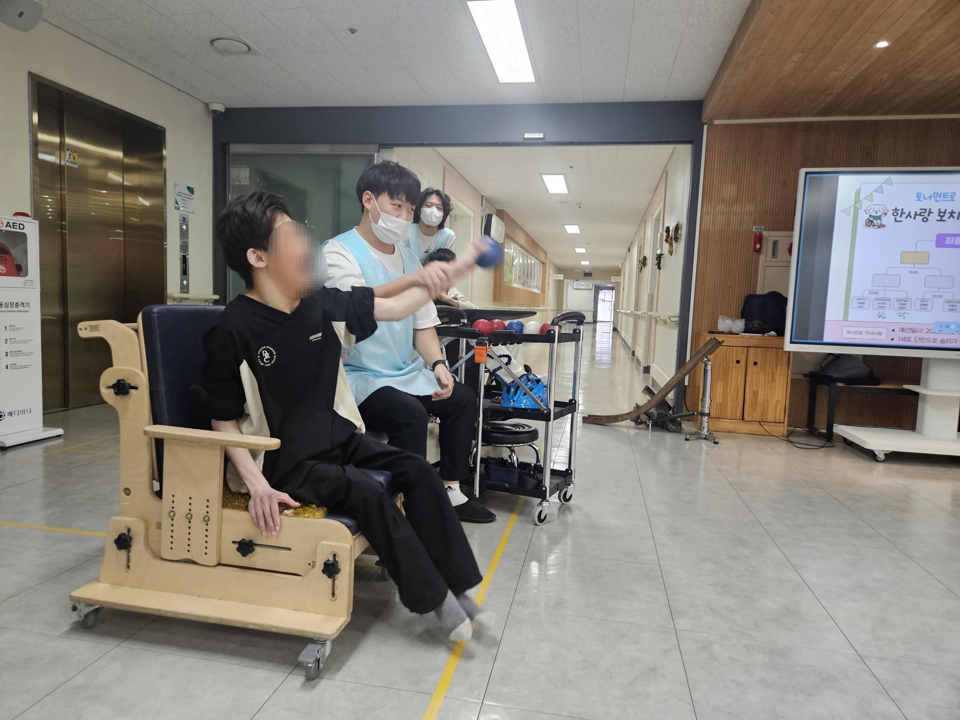 선생님(직원)과 함께 공을 던지고 있는 이용자