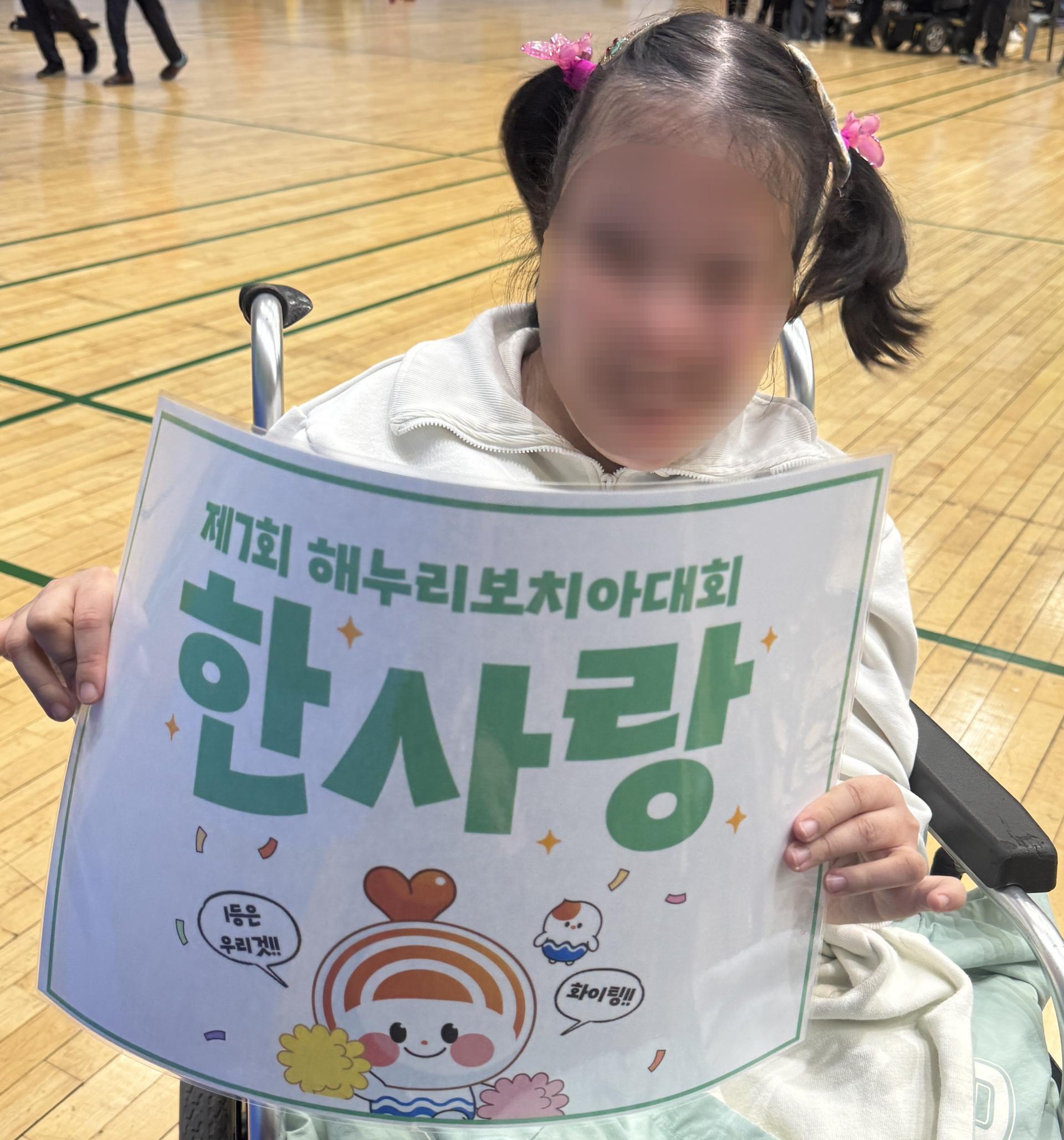 보치아대회 한사랑 푯말을 들고 웃는 이용자