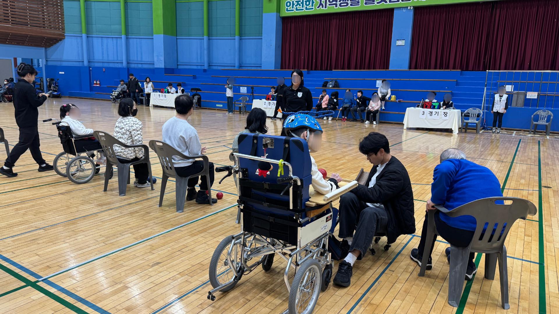 이용자가 공을 굴릴수 있도록 호흡을 맞추며 홈통을 조절해주는 한사랑마을 언어치료사와 참가한 사람들 사진