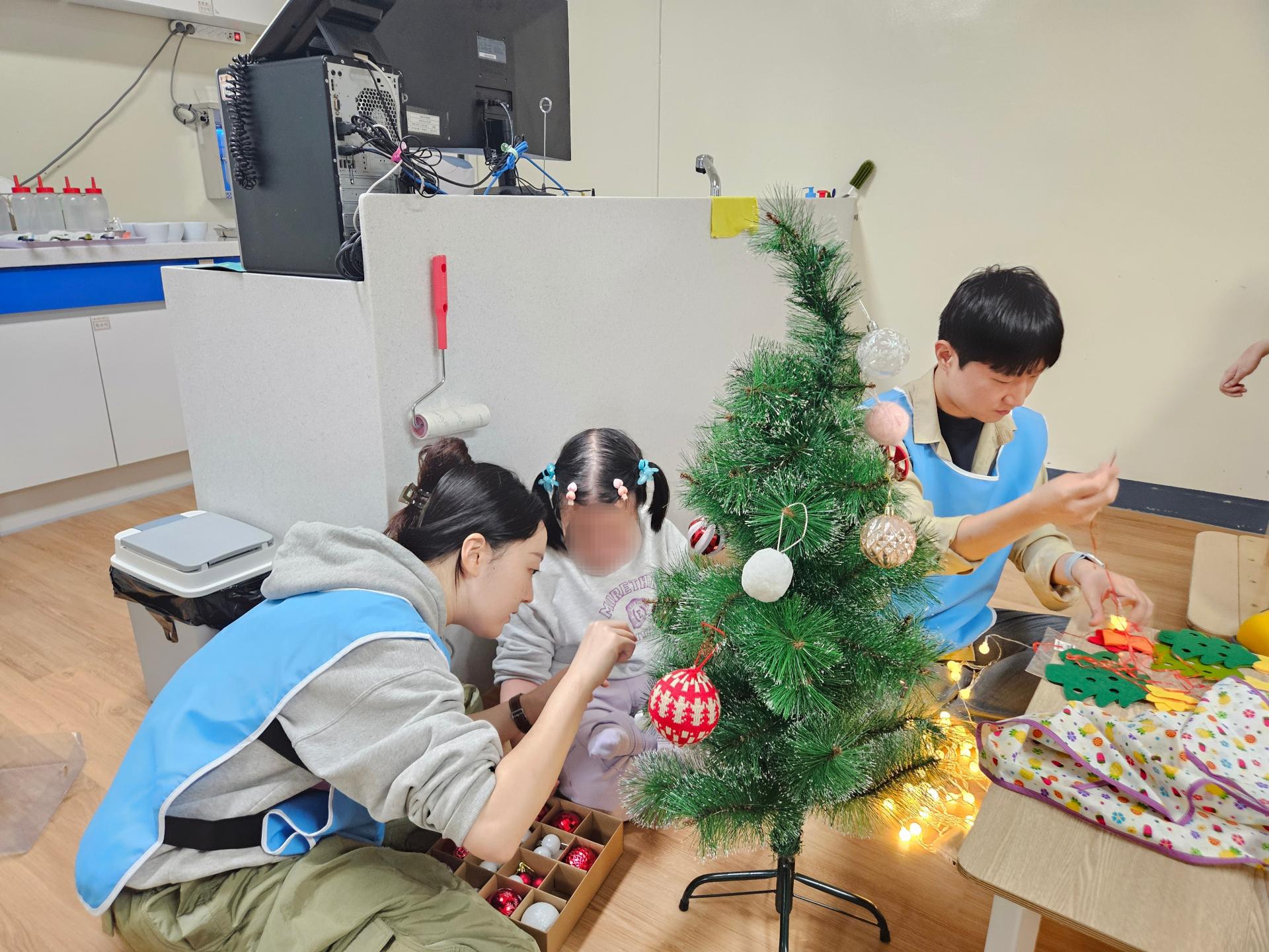 이용자와 함께 트리를 만드는 봉사자