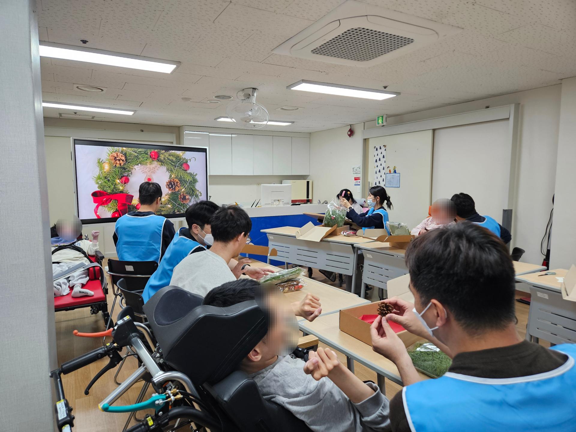 이용자와 함께 생화리스를 만드는 봉사자