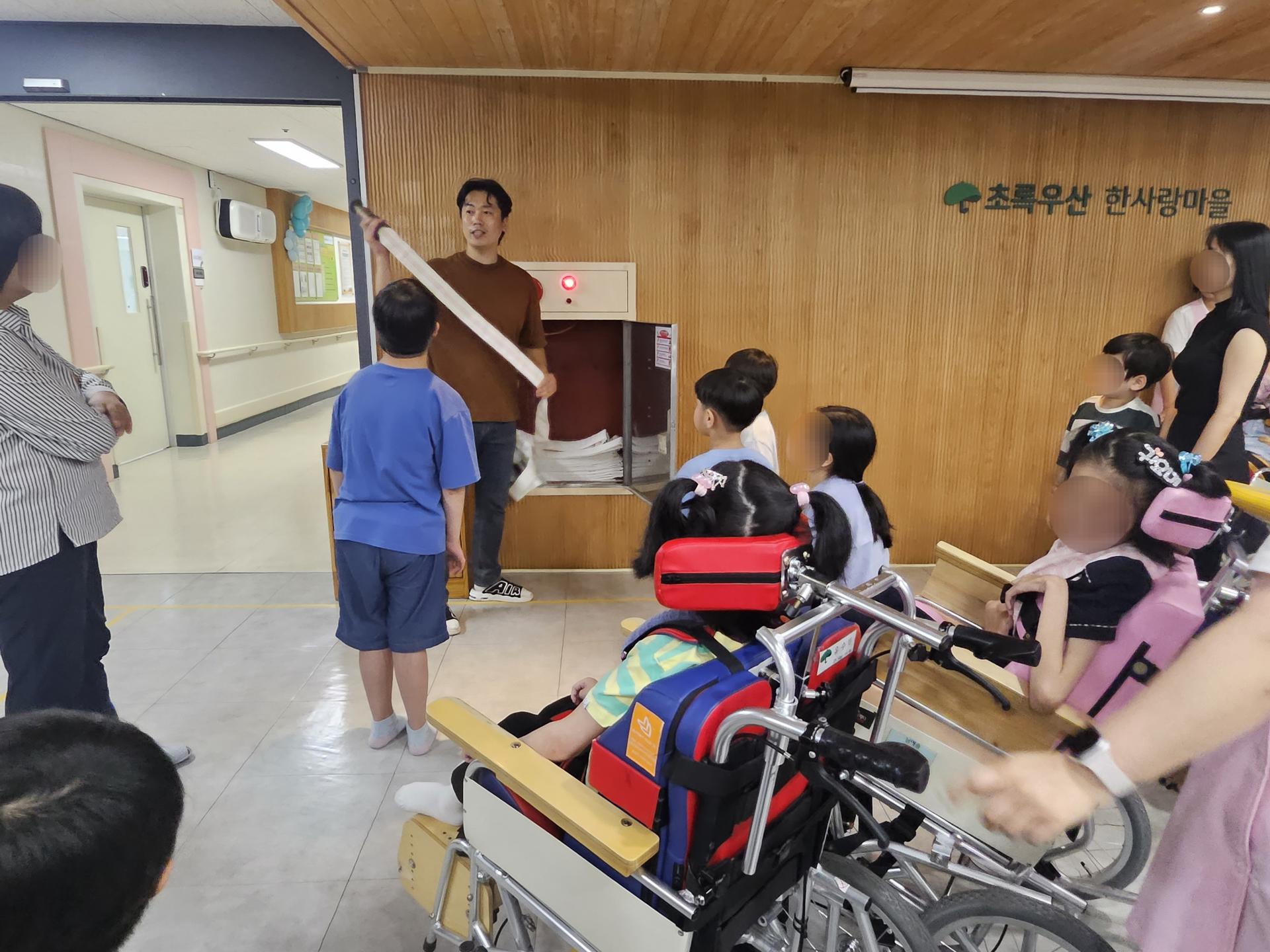 소화전에 대해 설명을 듣고 있는 이용자와 직원들