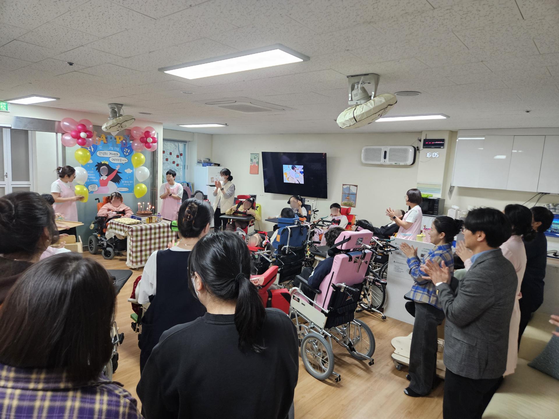 퇴소 이용자를 응원하며 박수를 치는 이용자와 직원들