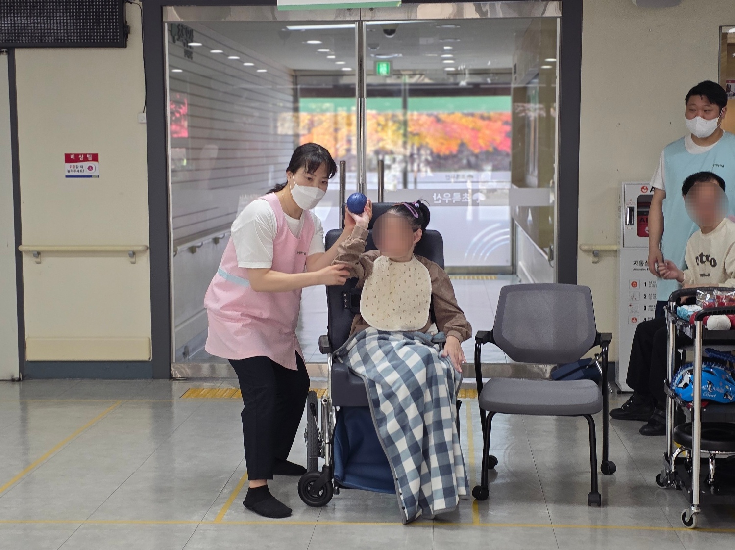 선생님(직원)과 함께 공을 던지고 있는 이용자