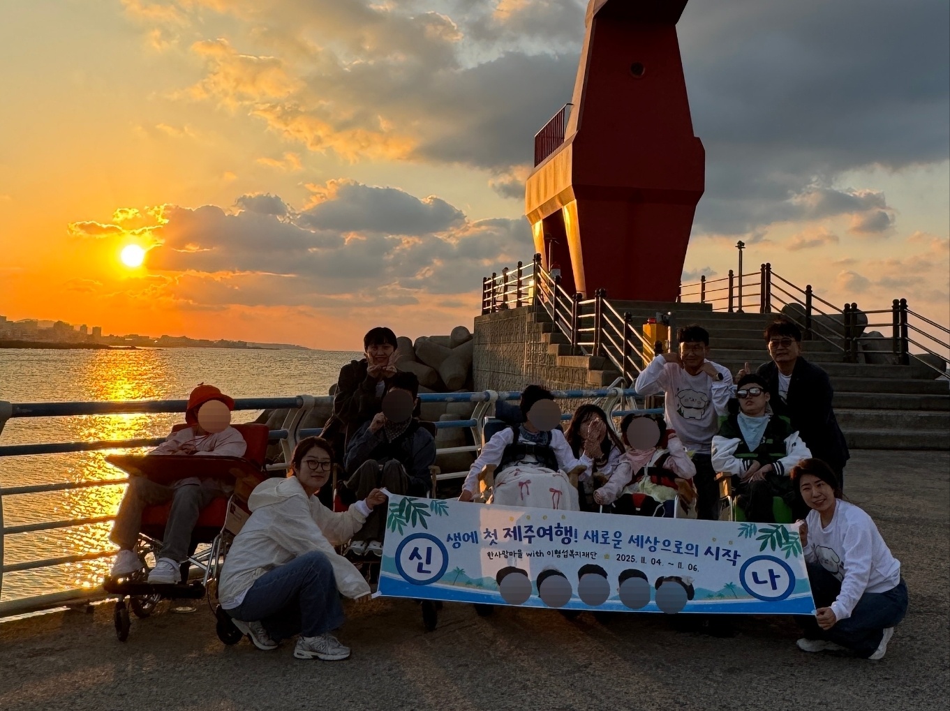 등대 앞에서 현수막과 함께 단체사진을 찍은 이용자와 직원들