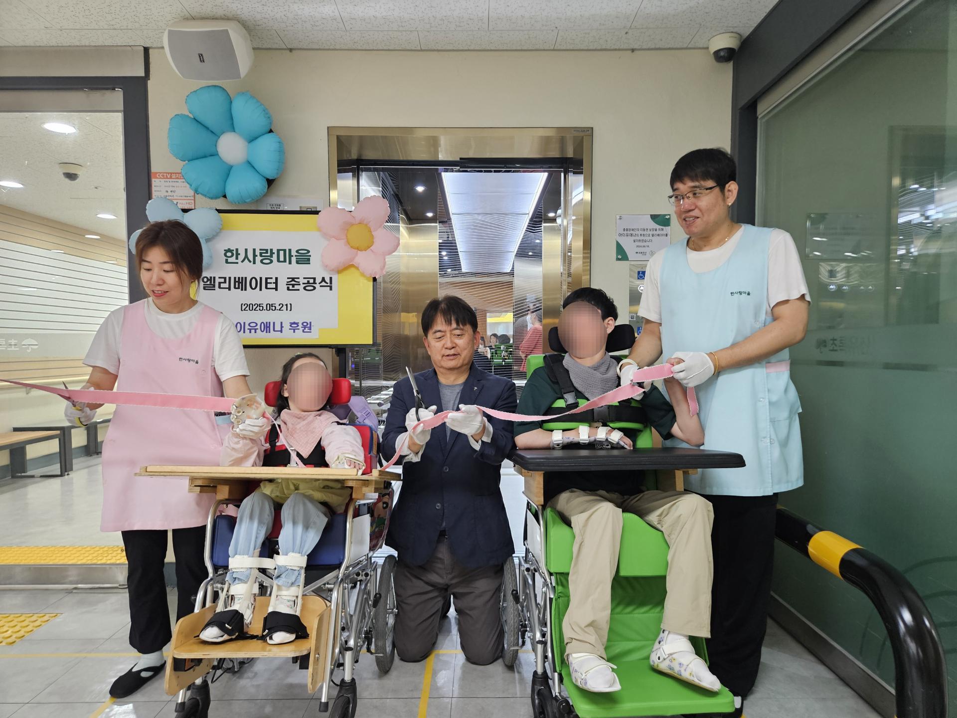 엘리베이터 앞에서 준공식을 진행한 이용자,직원,원장님