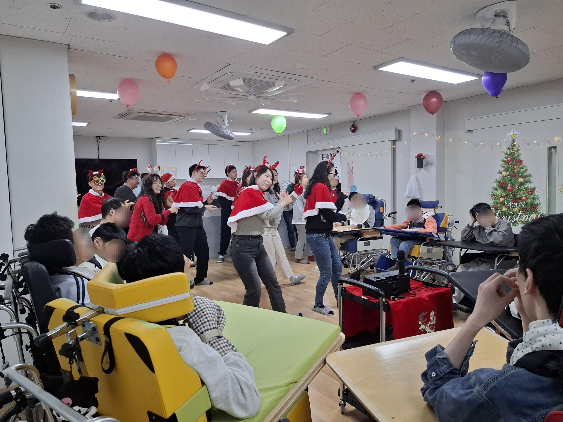 캐롤 율동 공연을 하는 봉사자들과 바라보는 이용자들