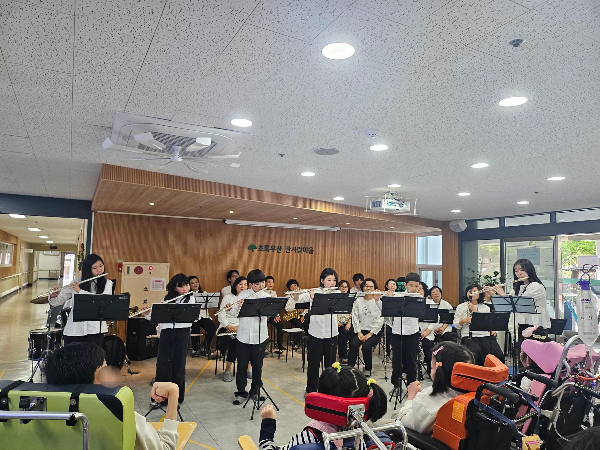 연주에 집중하는 이용자들과 초등학생 단원들 