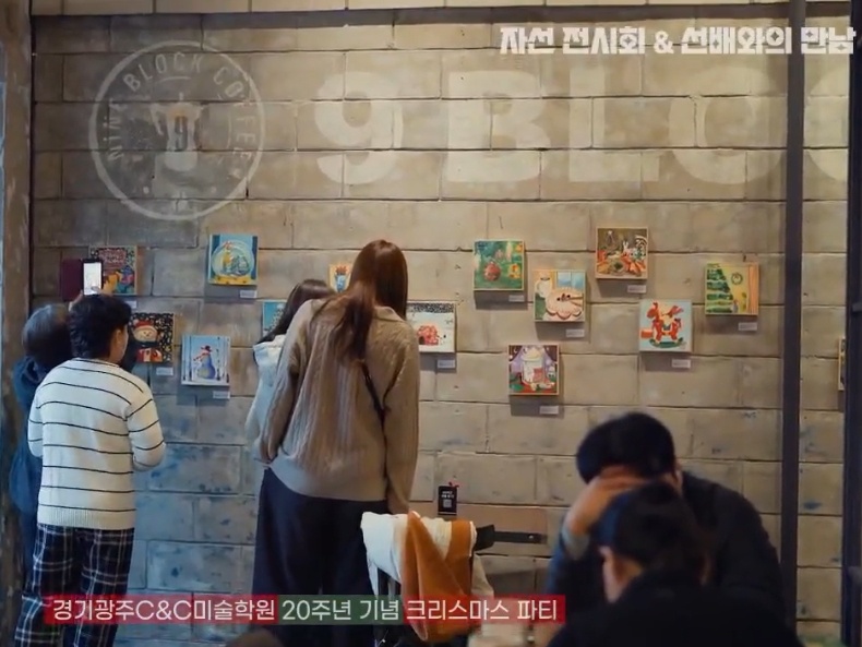 나인블럭 카페에서 전시된 그림을 보는 사람들