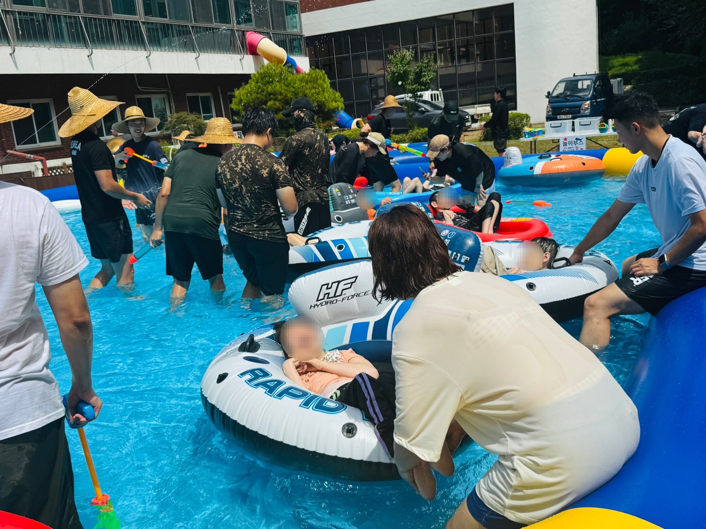 튜브를 탄 이용자가 물놀이를 즐길수 있게 함께하는 자원봉사자들