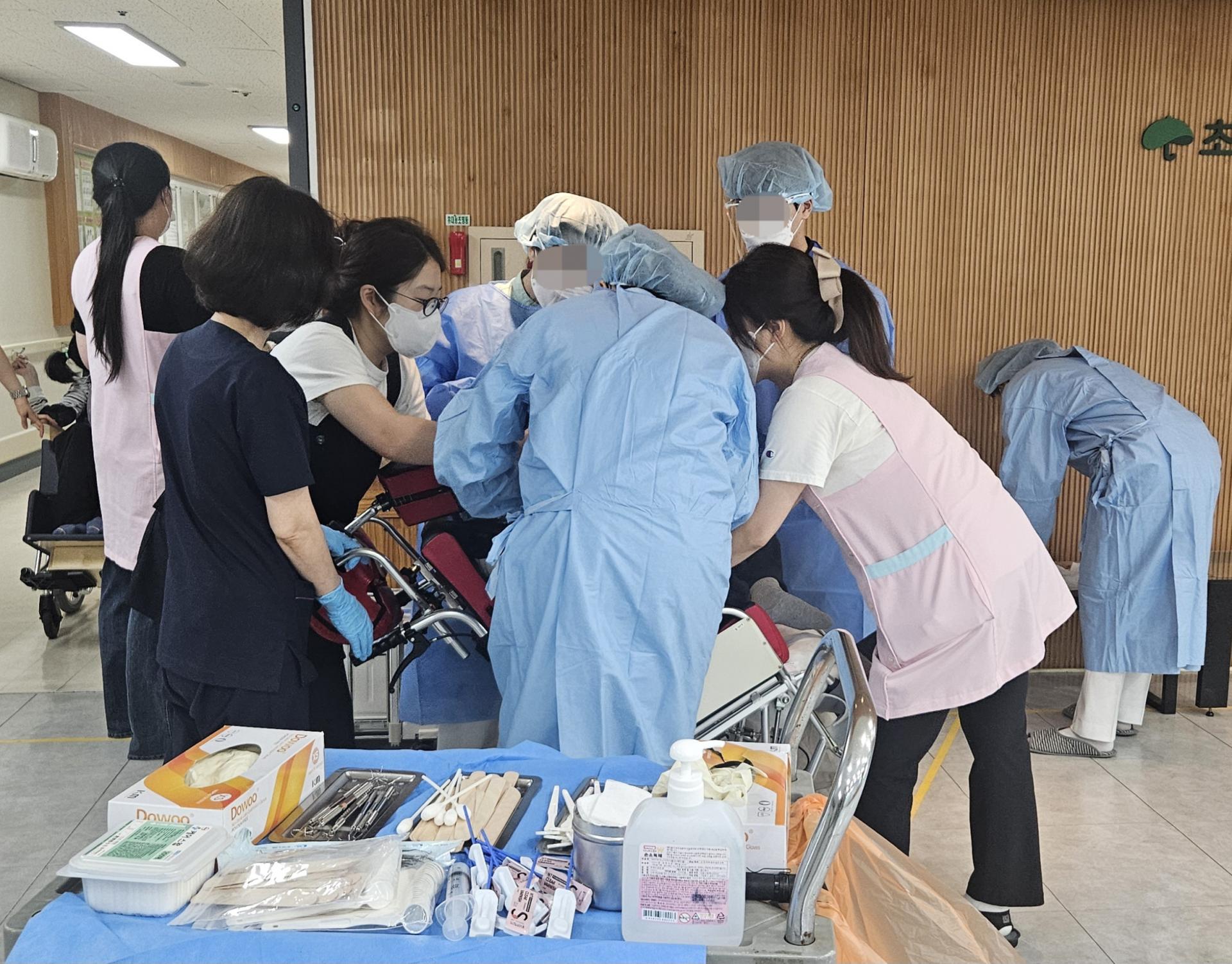 구강검진을 받는 이용자와 진행하는 의료진들