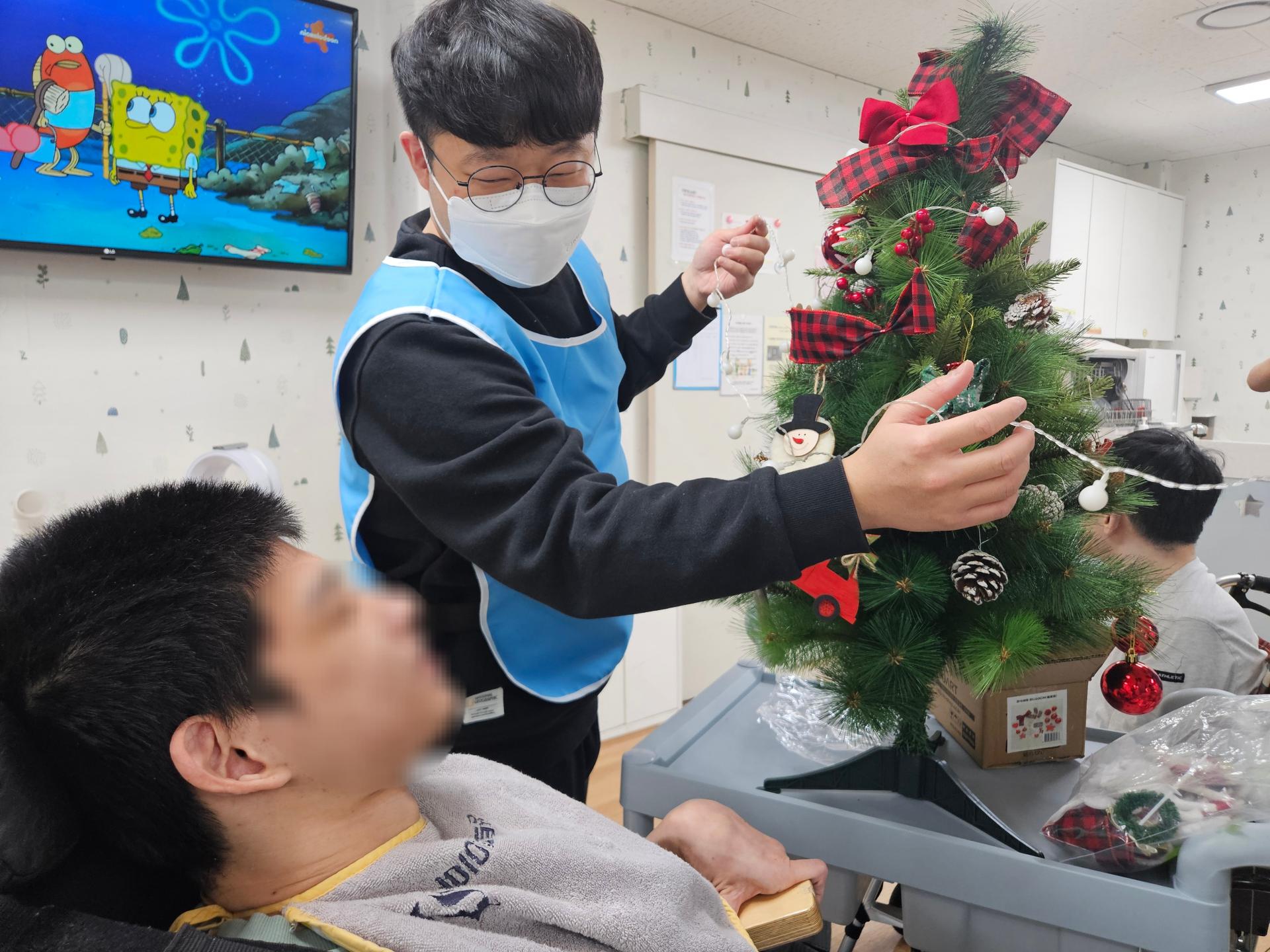 이용자와 함께 트리를 만드는 봉사자