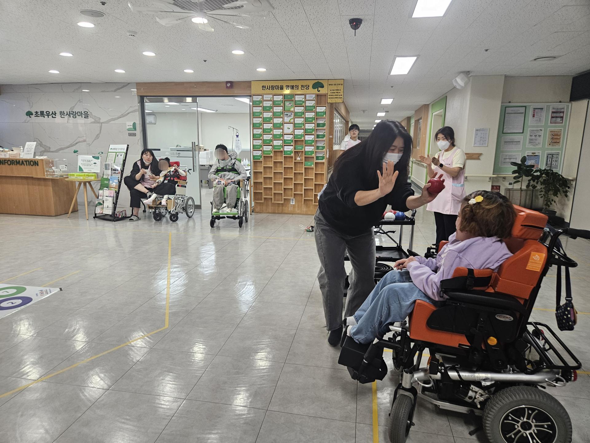 한팀이 되어 경기하는 도중 점수가 잘 나오자 하이파이브를 하고 있는 이용자와 직원