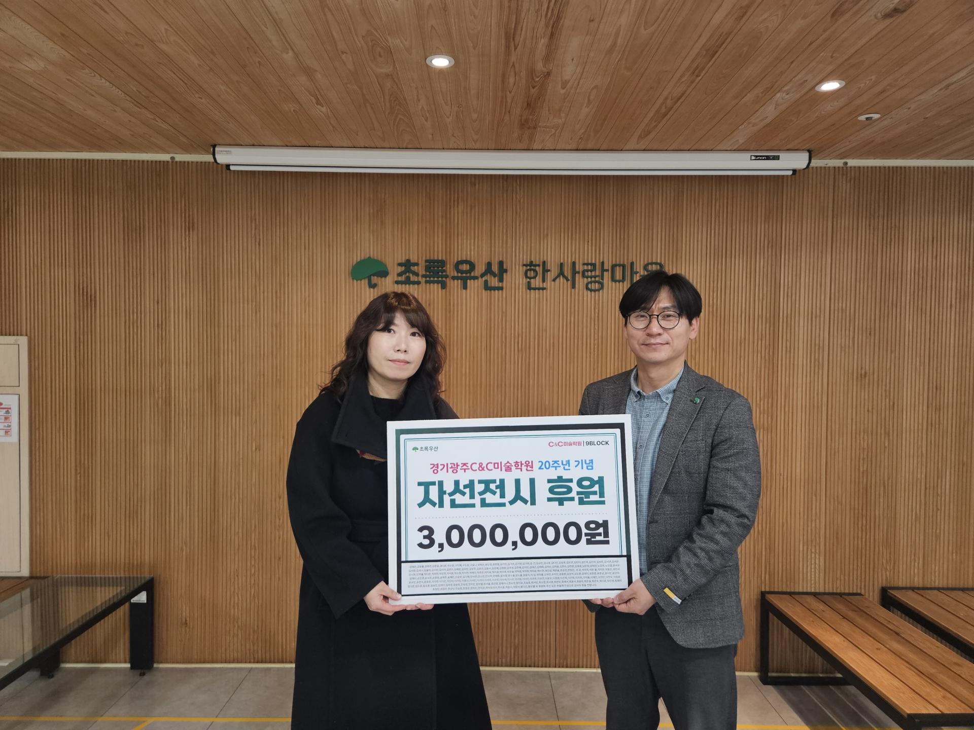 후원금 전달 현판을 들고 있는 미술학원 원장님과 한사랑마을 원장님 모습