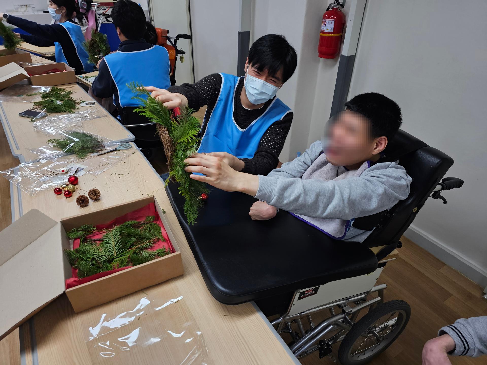 이용자와 함께 생화리스를 만드는 봉사자