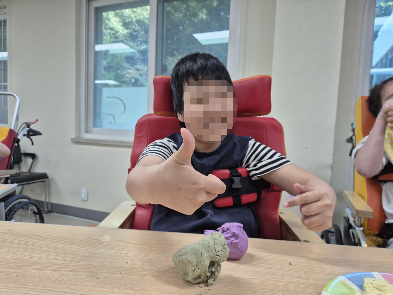 송편 반죽을 만져보며 엄지척을 하고 있는 이용자