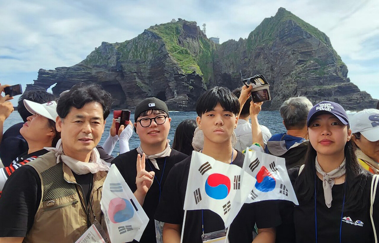 독도접안은 못해지만 독도를 배경으로 기념촬영을 하고 있는 탐방단. /독도사랑회