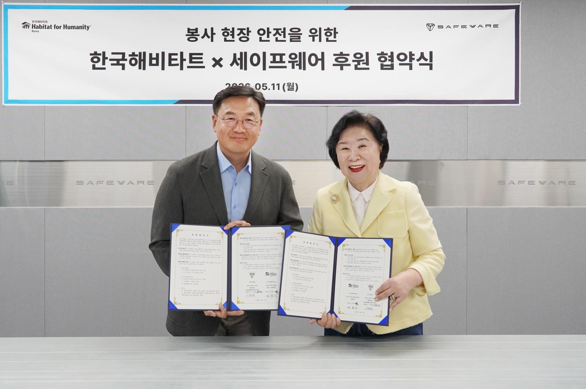 정도우 세이프웨어 경영관리본부장과 마희자 한국해비타트 이사장이 업무협약 체결 이후 사진 촬영하고 있다.