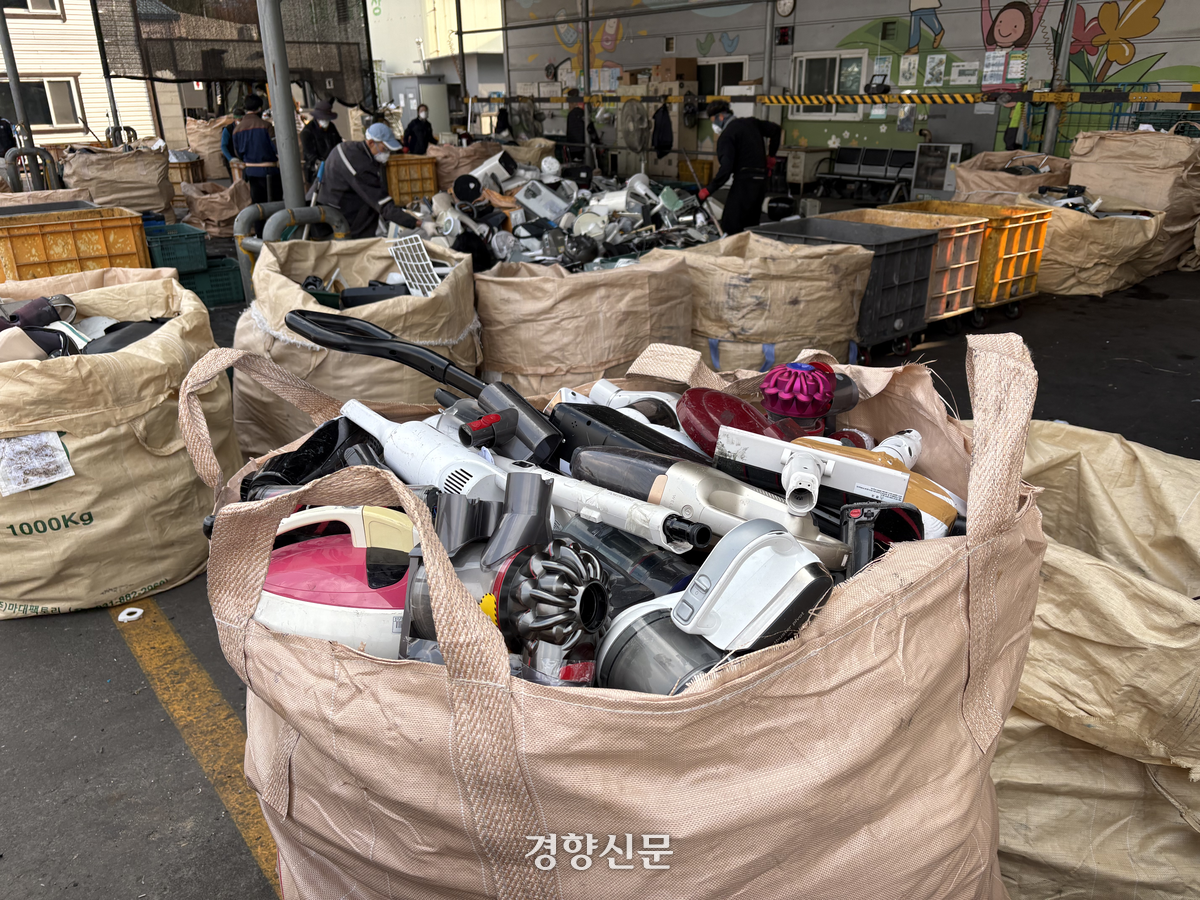 지난달 20일 서울 성동구 서울도시금속회수센터 야외선별장에서 노동자들이 폐전기전자제품을 종류별로 분류해 마대 자루로 옮겨 담고 있다. 오경민 기자