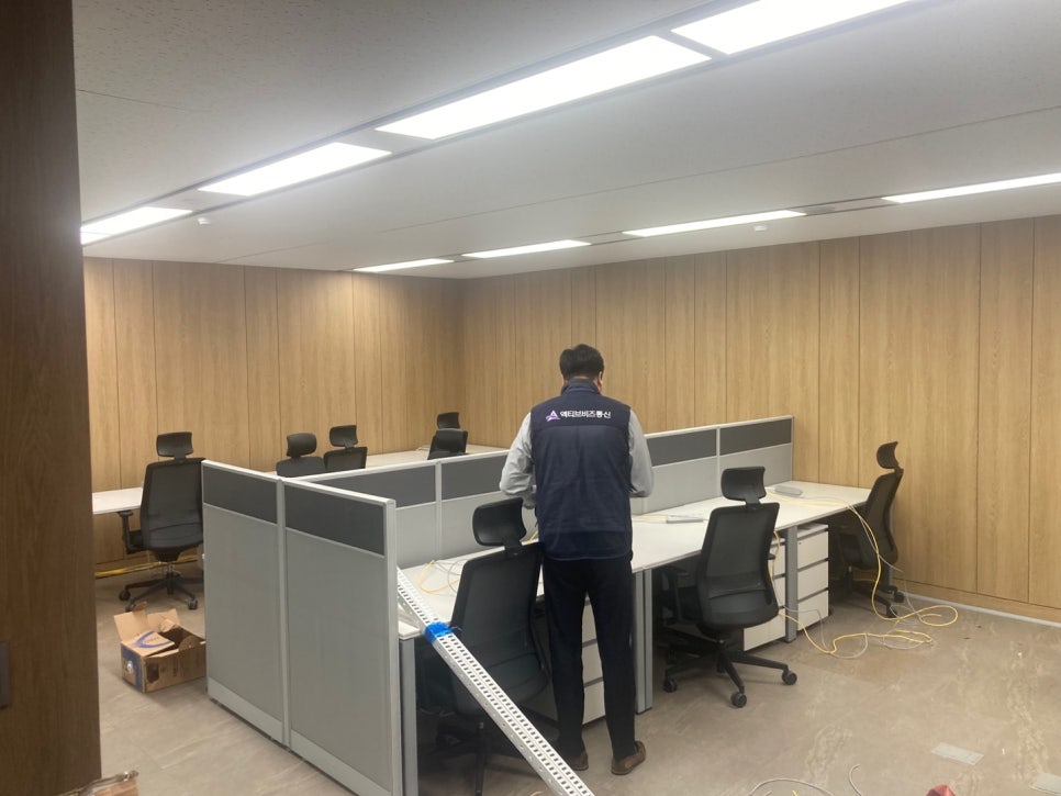 망분리 공사 중인 모습, 유선전화 시스템 설치 작업을 진행 중인 통신 엔지니어와 작업 중인 사무실 전경