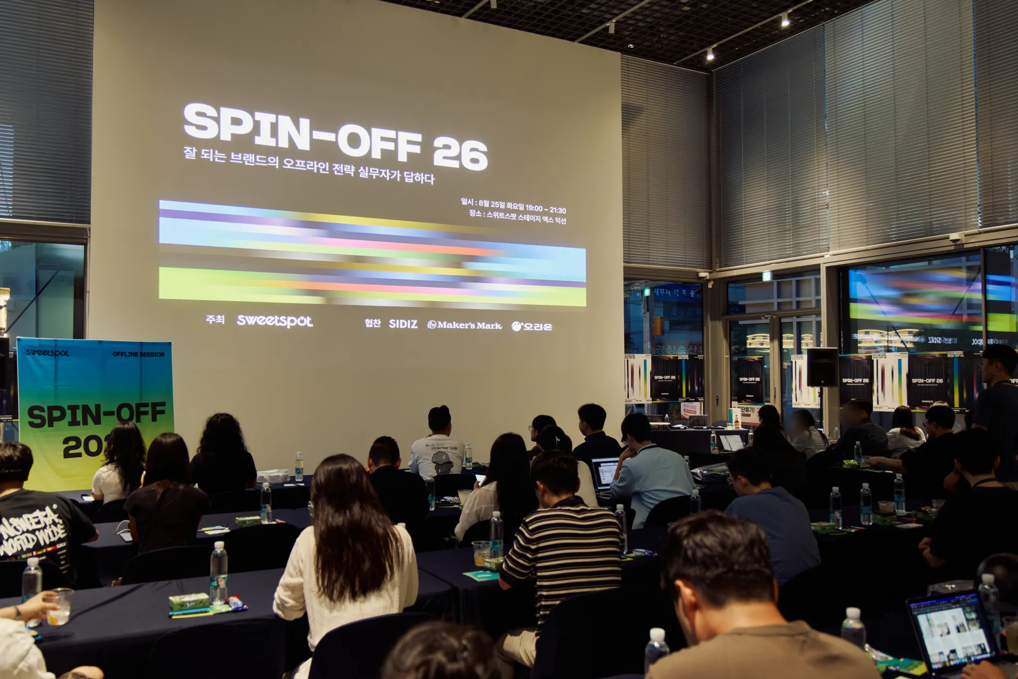 무대 스크린에 SPIN-OFF 26 타이틀 슬라이드가 띄워진 스테이지 엑스 익선 세션장 전경