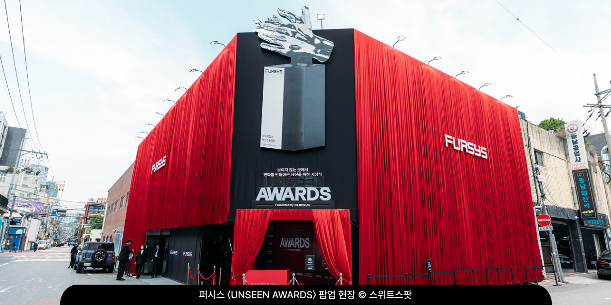 붉은 커튼과 대형 트로피 조형물로 시상식장처럼 꾸민 성수동 퍼시스 〈UNSEEN AWARDS〉 팝업 외관