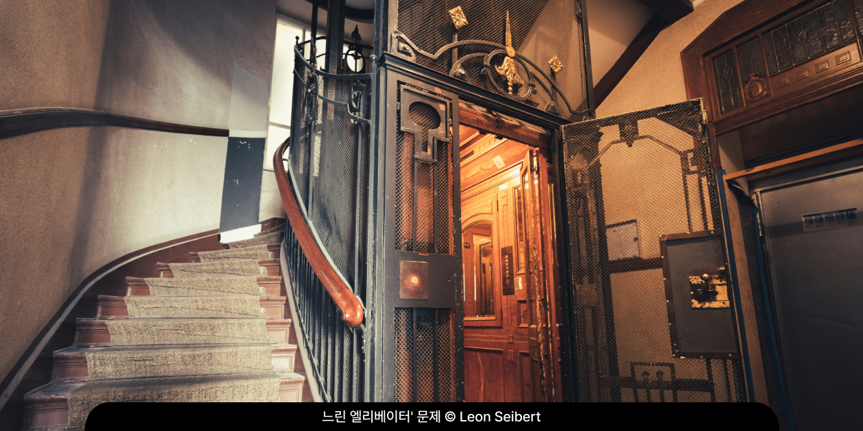 오래된 건물의 계단 옆에 놓인 낡은 엘리베이터, 느린 엘리베이터 문제를 상징하는 이미지
