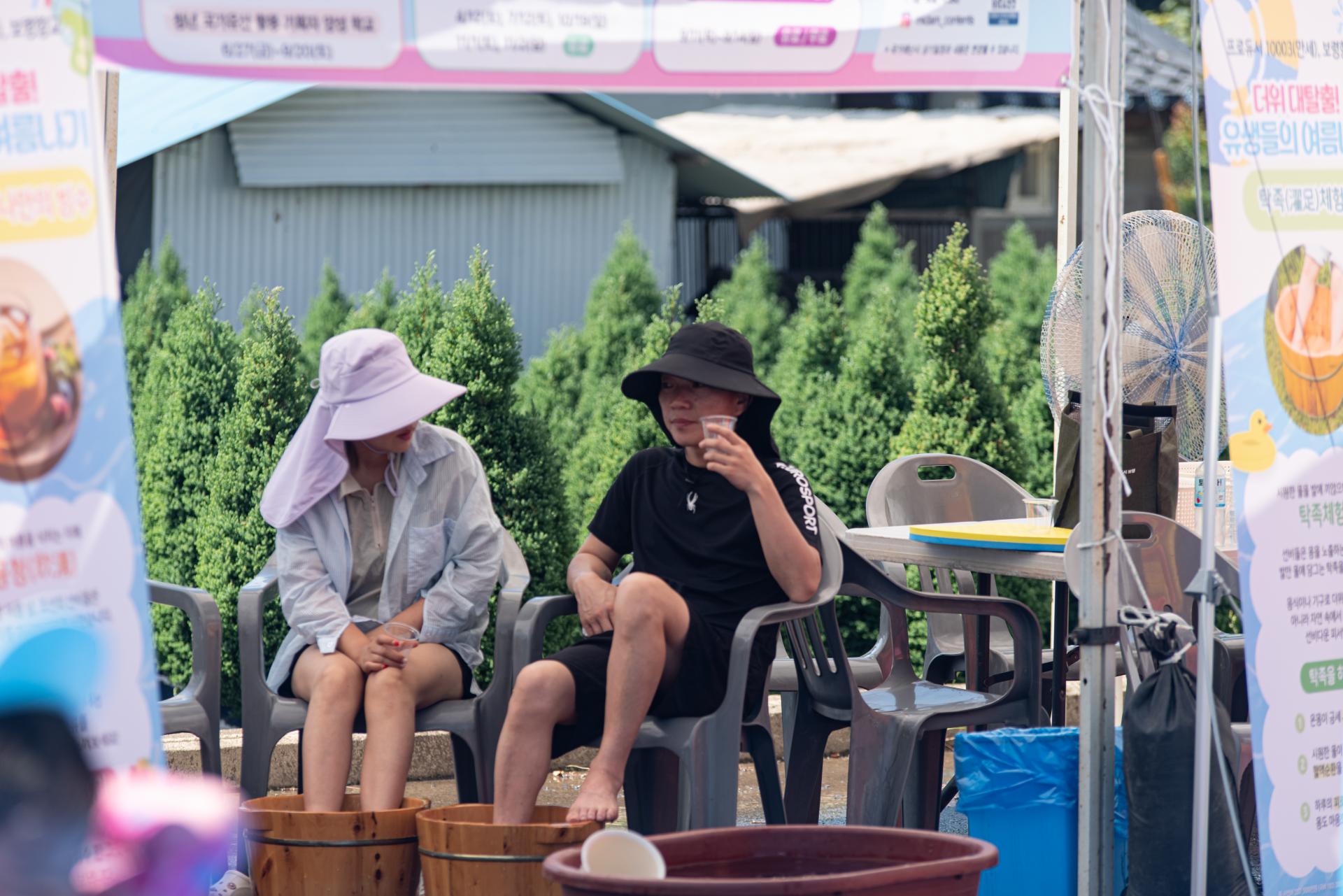 보령 보령향교 - 참여자들이 야외 쉼터에 앉아 족욕 체험을 하며 휴식을 취하고 있다