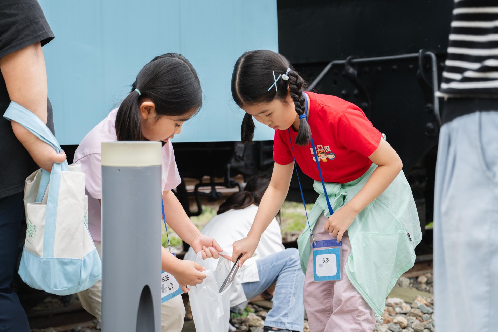 노원 화랑대역 - 봉투와 집게를 들고 쓰레기를 줍는 아이들