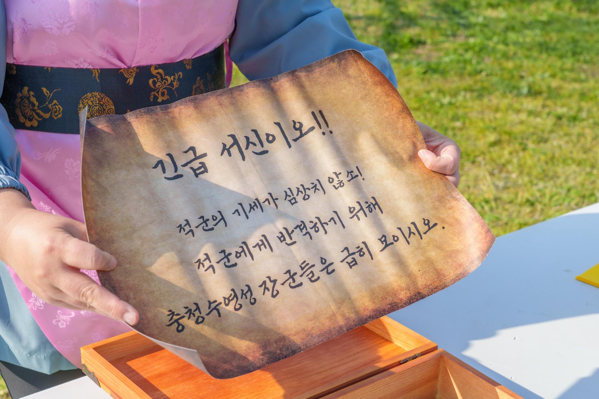 보령 충청수영성 - 전통 수군 복장을 입은 어린이 참가자가 상자 안에서 미션의 내용이 서신처럼 꾸며진 미션지를 꺼내 들고 있다