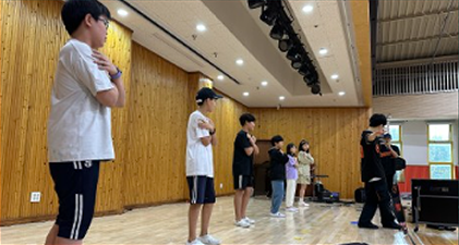 갬블러크루와 학생들이 실내 체육관에서 춤추는 모습