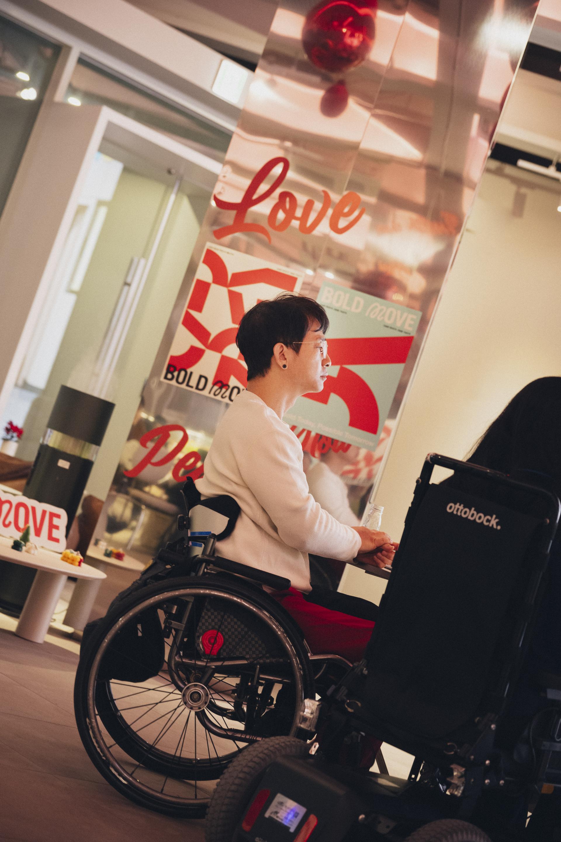 볼드무브 남성 멤버가 휠체어에 앉아 그라운드 220 전시 공간에서 강연을 듣고 있다.