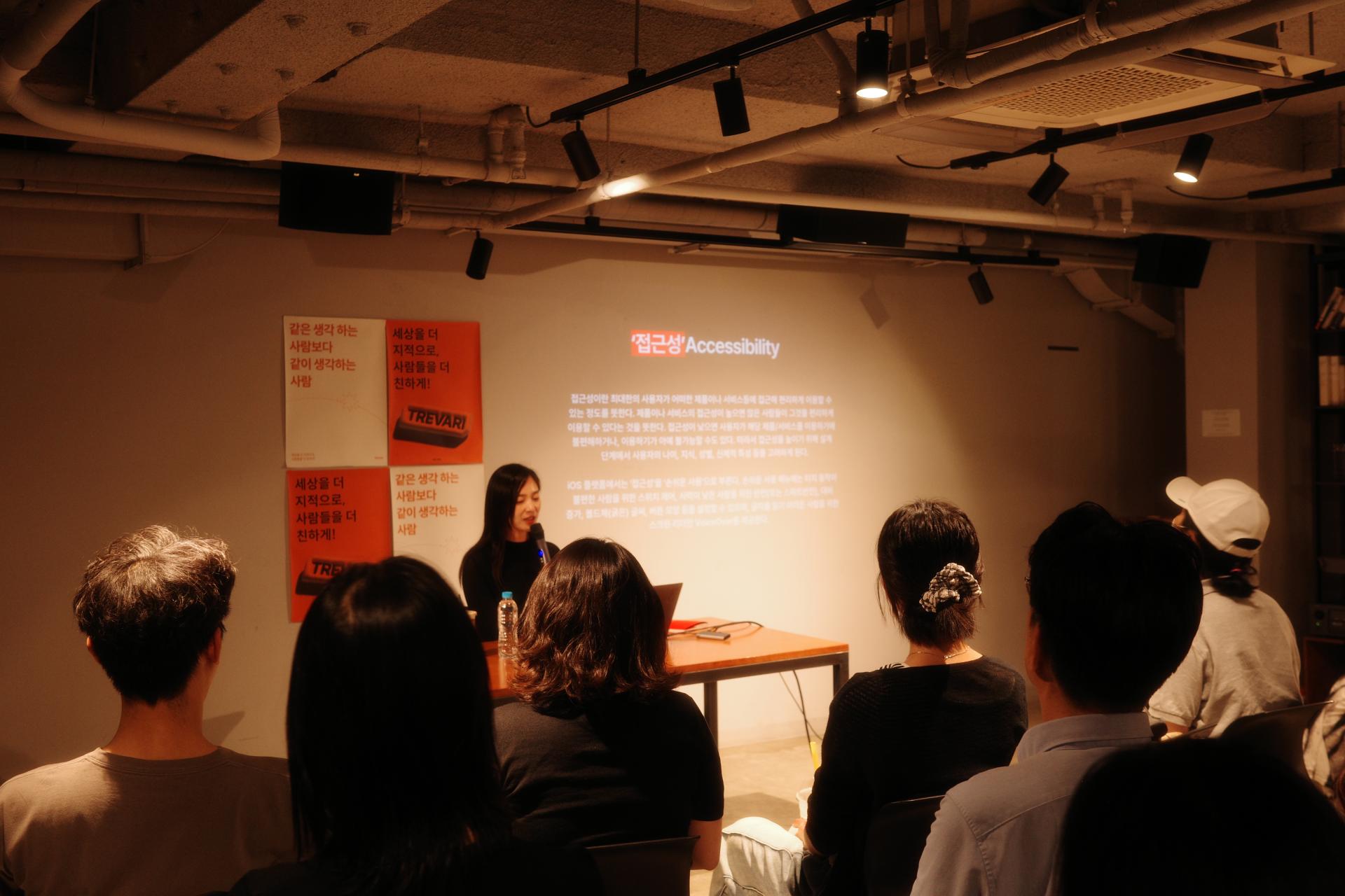 스크린에 ‘접근성 Accessibility’에 대한 내용이 보이고, 발표자가 관객 앞에서 설명하고 있다.