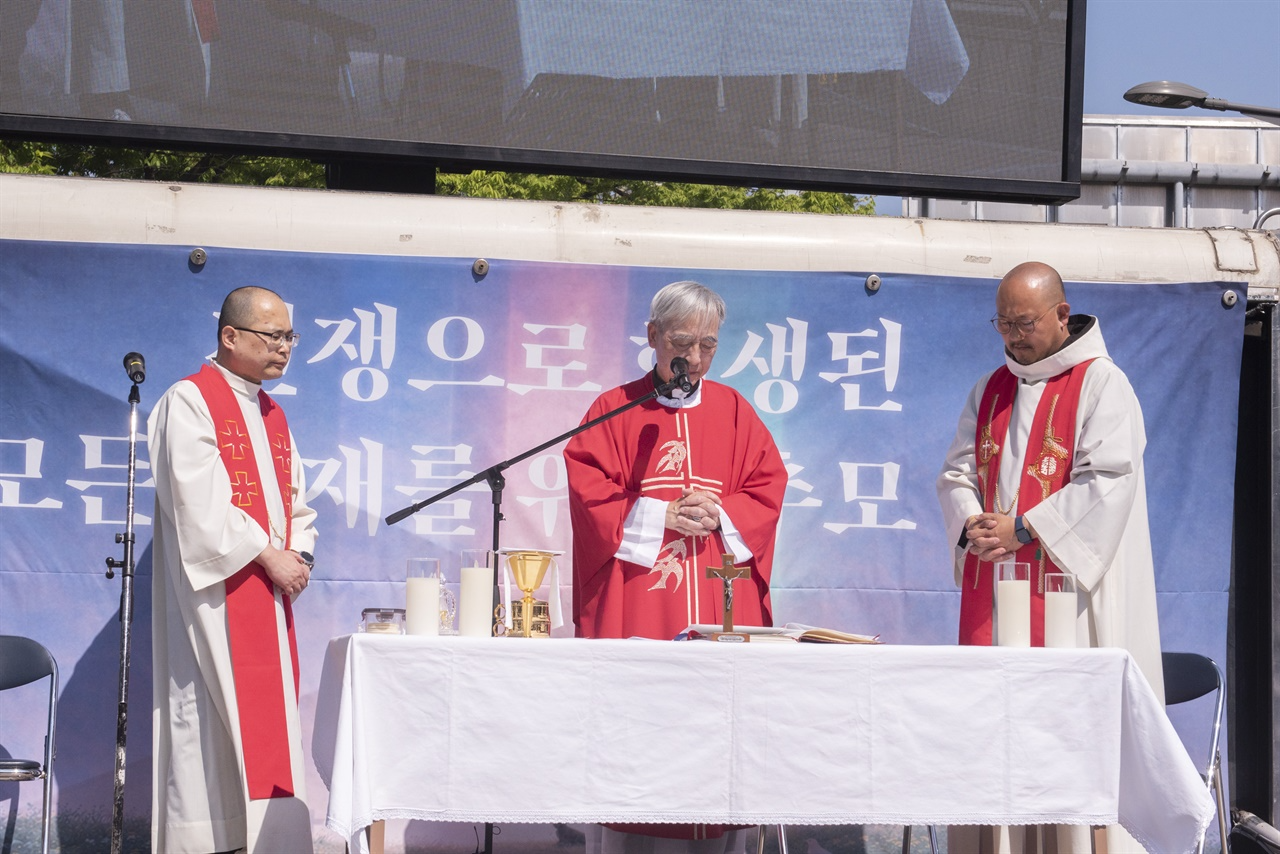 전쟁기념관 앞에서 ‘전쟁으로 희생된 모든 존재를 위한 추모 미사’를 집전하고 있는 강우일 주교와 사제단
