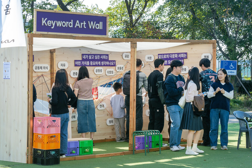 지난해 10월26일 서울 용산구 노들섬에서 열린 '하모니움 페스티벌' 방문객들이 '키워드 아트월: 발견의 기쁨' 부스에서 다문화를 상징하는 키워드들을 직접 다양한 색상의 털실로 연결하는 체험을 하고 있다. [사진 기아]