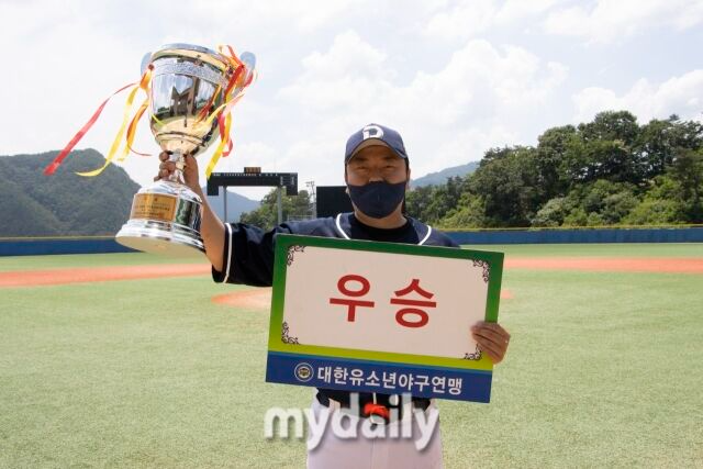 우승컵을 들고 세리머니하는 윤정호 감독.