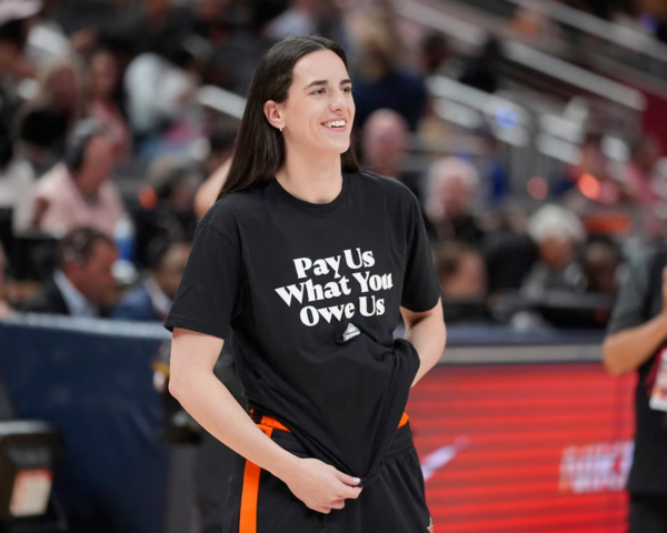 WNBA 인디애나 피버 소속 케이틀린 클라크가 지난 19일 미 인디애나폴리스 게인브리지 필드하우스에서 열린 WNBA 올스타전에서 ‘우리가 받아야 할 돈을 달라(Pay Us What You Owe Us)’라는 문구가 적힌 티셔츠를 입고 있다. ⓒAP연합뉴스