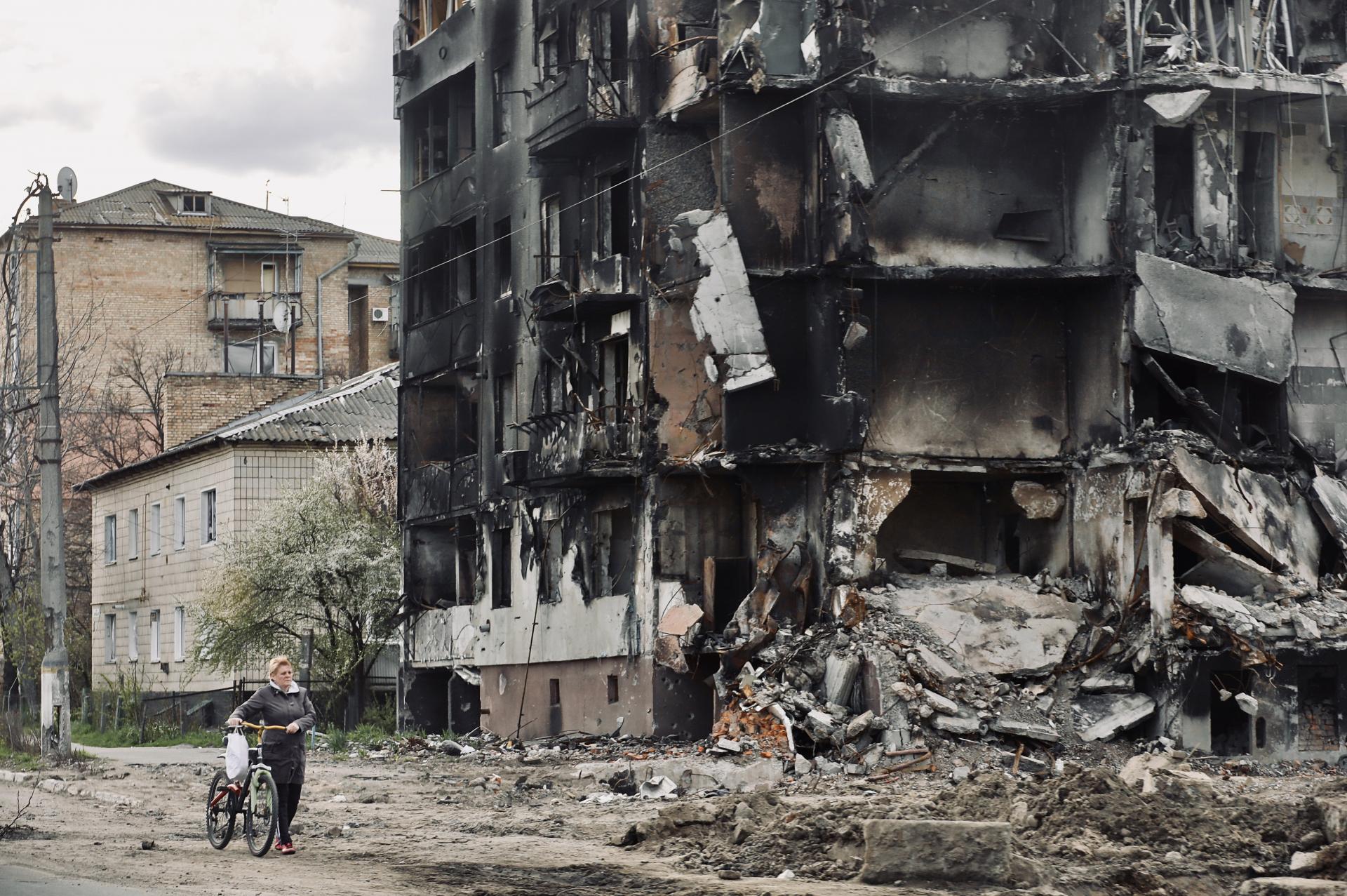폐허 건물을 지나는 우크라이나 민간인