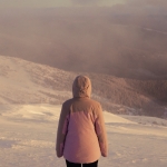 A woman standing on top of a snow covered slope
