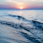 The sun is setting over the ocean waves