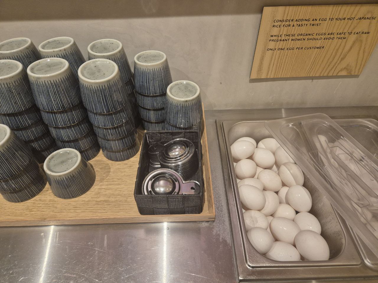 무한 리필 가능한 밥과 함께 제공되는 신선한 유기농 날달걀 셀프 코너 및 식기류