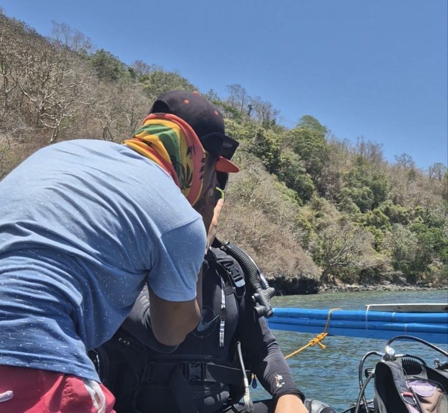 다이빙 입수 전 가이드의 도움을 받아 장비를 착용하는 모습